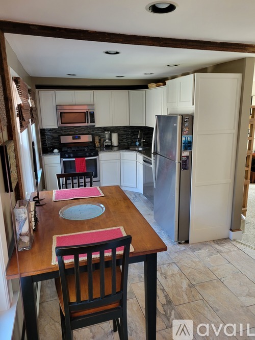 A kitchen with a table set for two with a pink placemat.