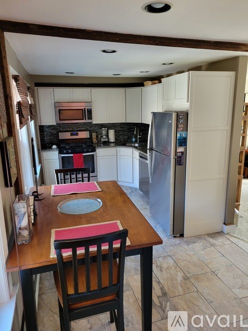 A kitchen with a table set for two with a pink placemat.