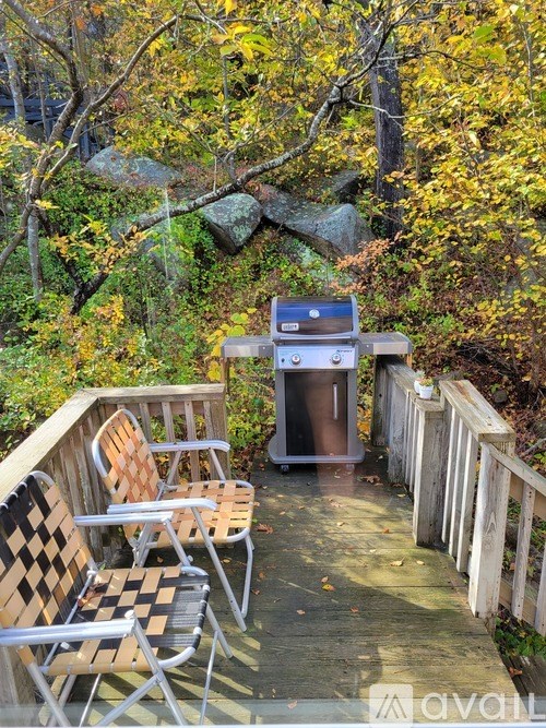 Two chairs and a table are on a wooden deck.