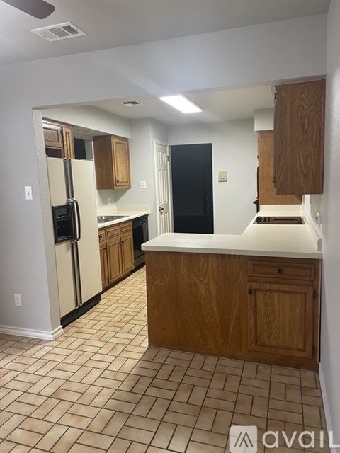 A kitchen with wooden cabinets and black appliances.