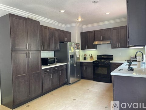 A kitchen with dark wood cabinets and stainless steel appliances.