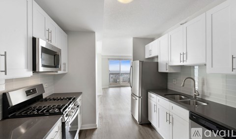 A kitchen with white cabinets and stainless steel appliances.