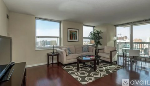 A living room with a couch, coffee table, and a large window.