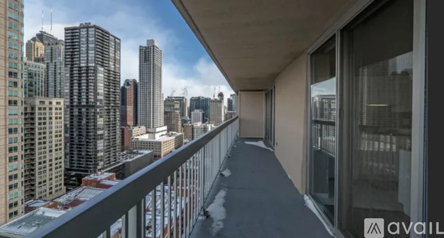 A balcony with a metal railing overlooks a cityscape.