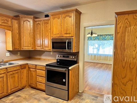 A kitchen with wooden cabinets and a stainless steel oven.