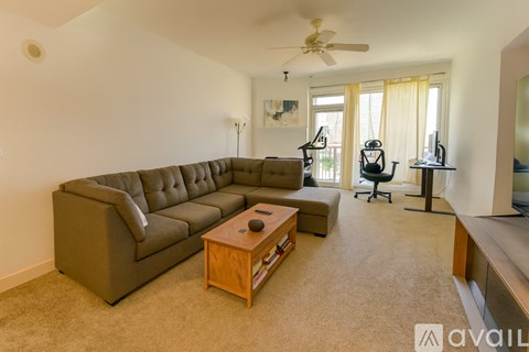 A living room with a brown sofa and a wooden coffee table.