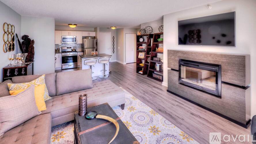 A living room with a grey couch and a fireplace.