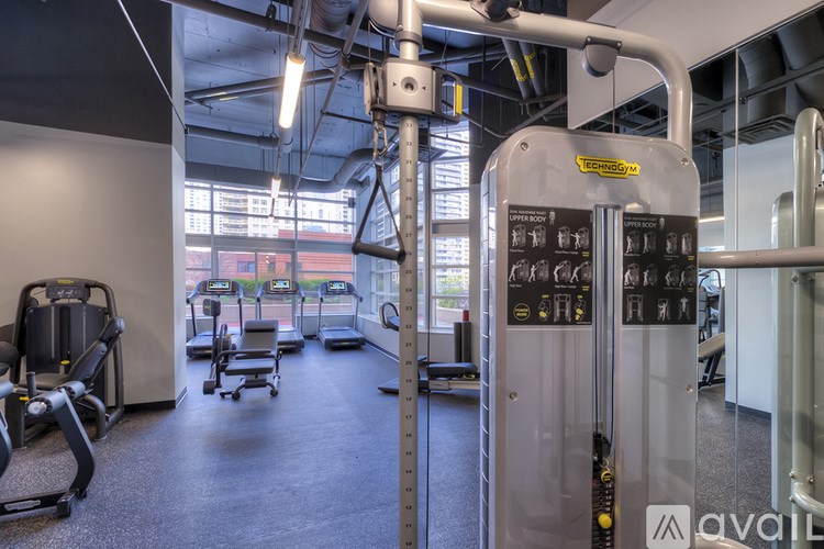 A gym with a variety of equipment including treadmills, stationary bikes, and weight machines.