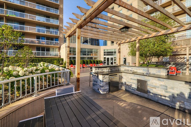A wooden pergola is over a patio with a table and chairs.