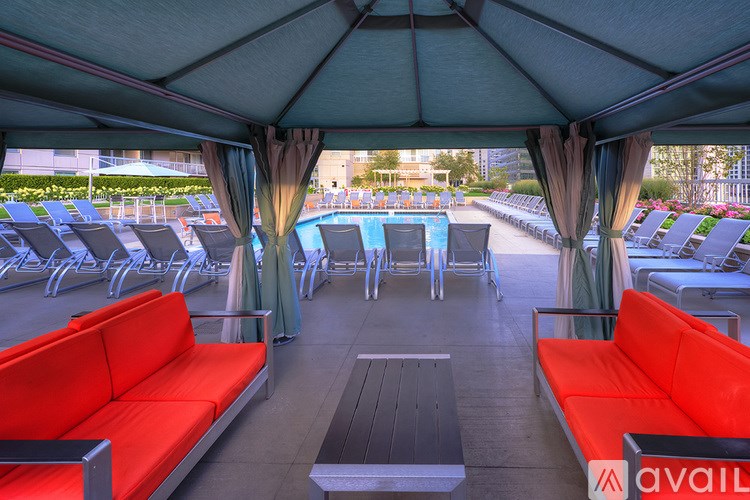 A large tent with red couches and a pool table in the middle.