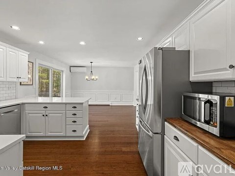 A kitchen with a refrigerator, microwave, and cabinets.