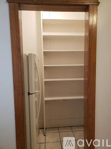 A white refrigerator with a wooden door frame.