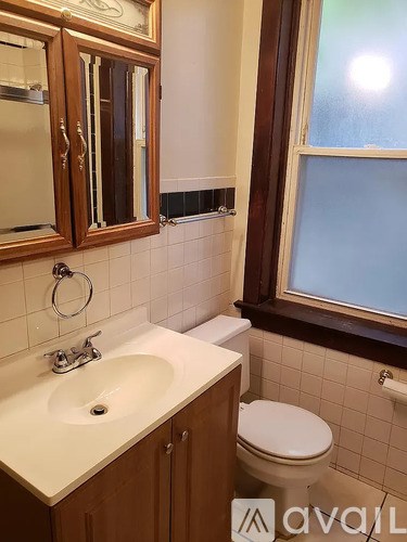 A bathroom with a toilet, sink, and mirror.