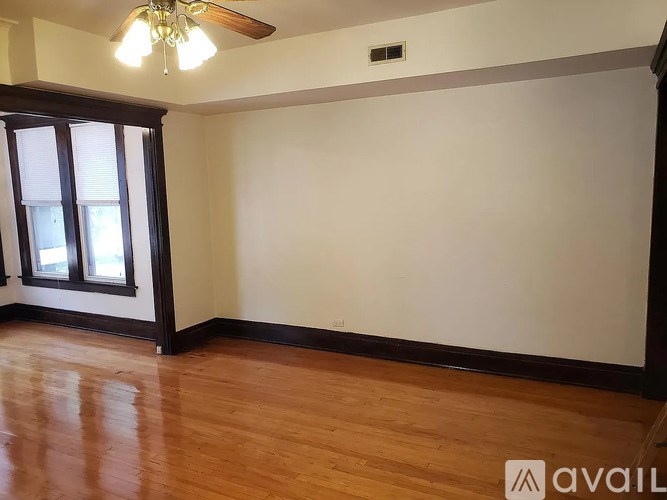 A room with wooden floors and a ceiling fan.