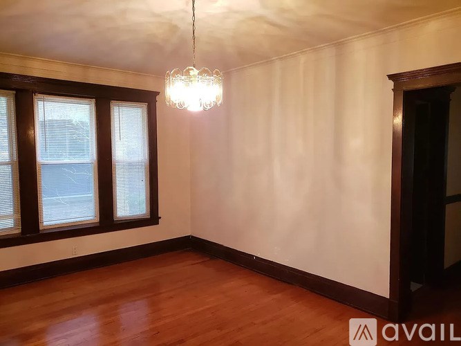 A room with wooden floors and a chandelier hanging from the ceiling.