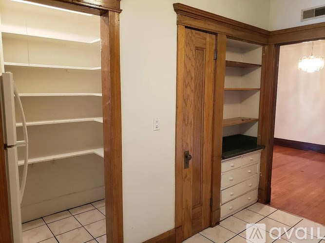 A kitchen with a white fridge and a wooden door.