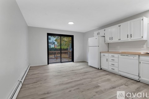 A kitchen with white cabinets and a wooden countertop.