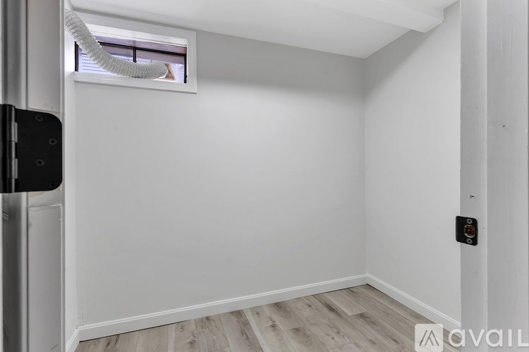 A small, empty room with a window and a door.