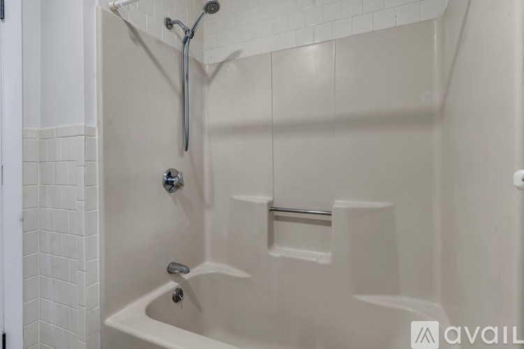 A white bathroom with a shower and a faucet.