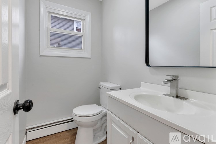 A white toilet sits next to a white sink in a bathroom.