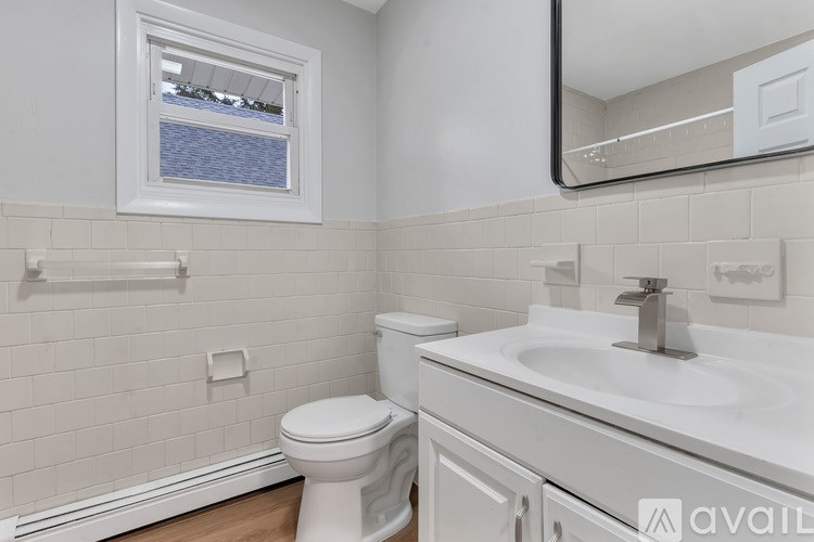A white toilet sits next to a white sink in a bathroom.