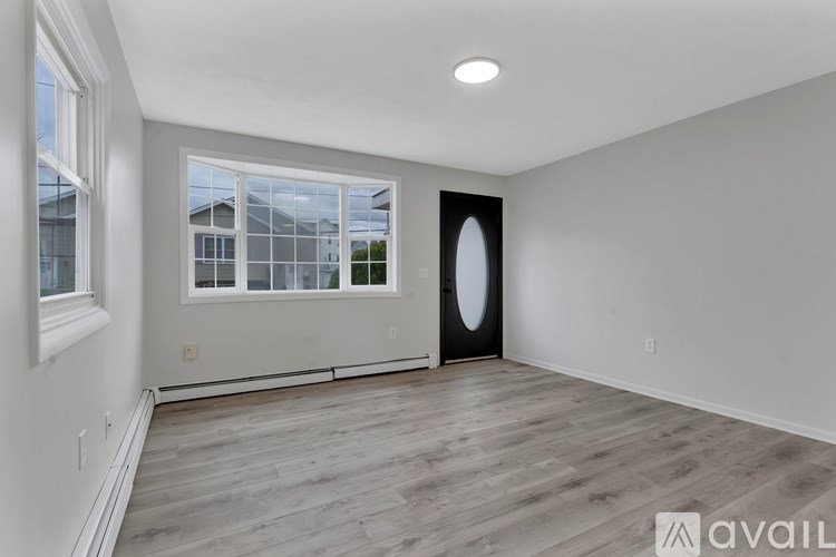 A spacious room with a large window and a door.