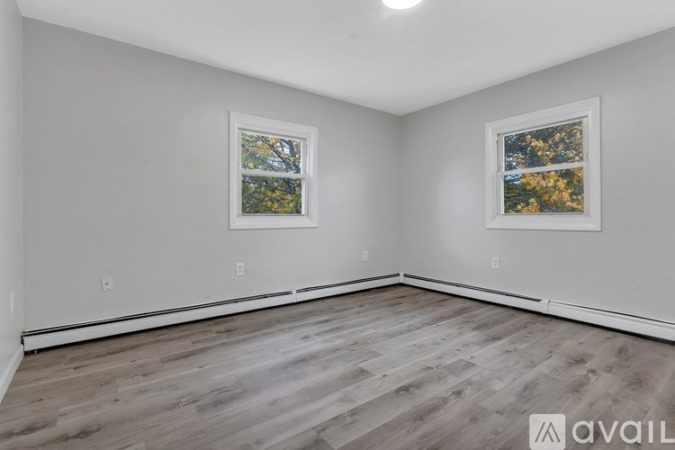 A room with wooden flooring and two framed pictures on the wall.
