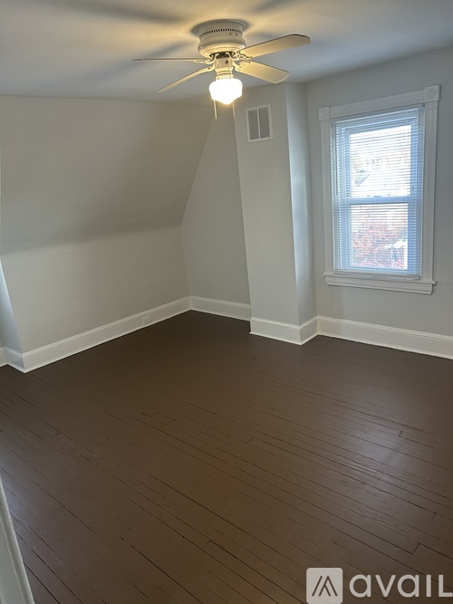A room with a ceiling fan and a window.