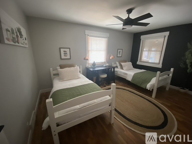 A bedroom with a white bed and a white chair.