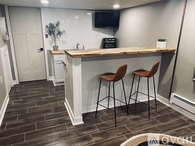 A kitchen with a bar and chairs.