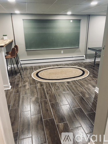 A room with a grey floor and a whiteboard on the wall.