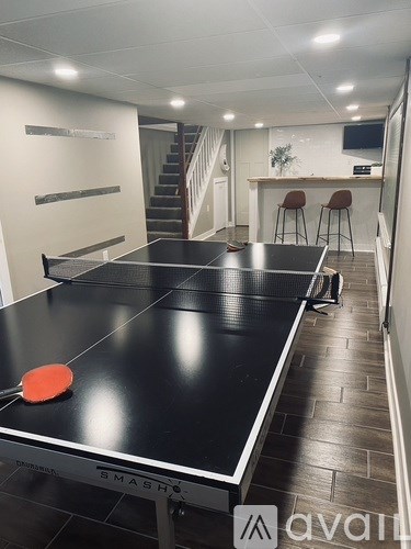 A ping pong table with a red paddle and ball on it.