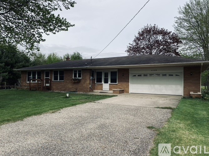 A house with a gravel driveway in front.
