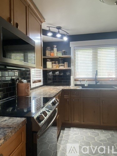 A kitchen with wooden cabinets and a black countertop.