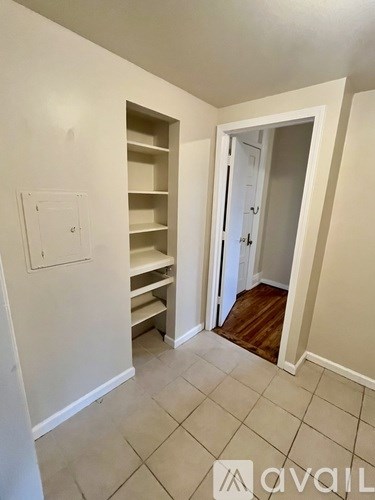 A room with a white wall and a doorway leading to another room.