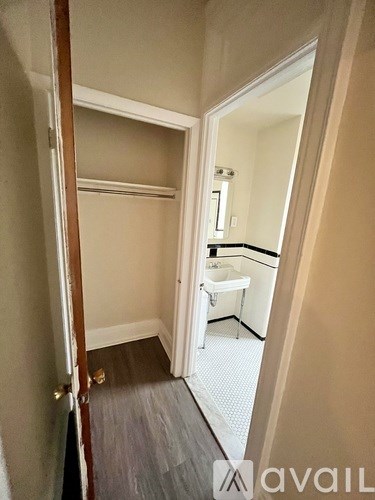 A bathroom with a toilet, sink, and mirror is visible through an open door.