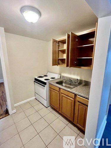 A kitchen with white appliances and wooden cabinets.