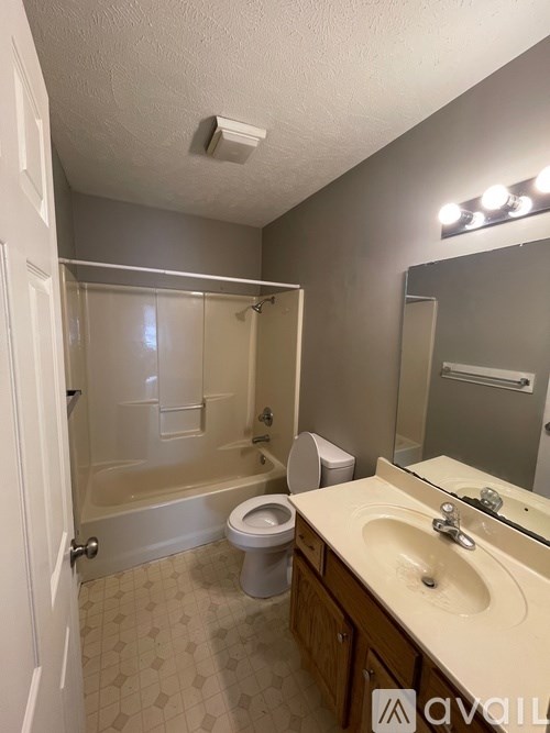 A bathroom with a toilet, sink, and shower.