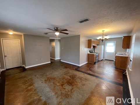A living room with a rug on the floor and a ceiling fan.