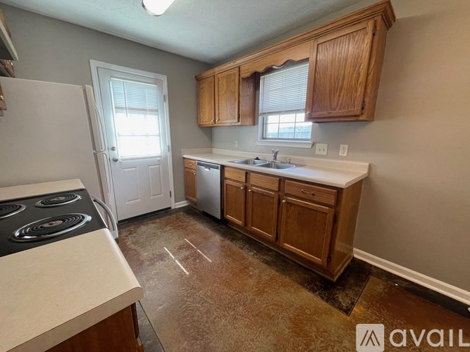 A kitchen with wooden cabinets and a white stove top oven.