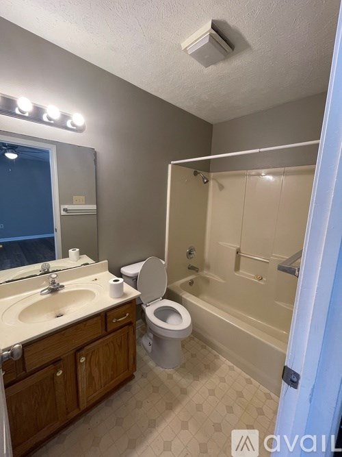 A bathroom with a toilet, sink, and bathtub.