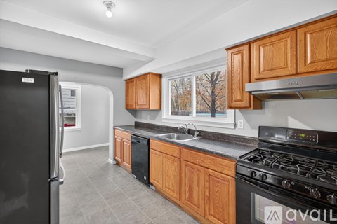 A kitchen with wooden cabinets and a black stove top oven.