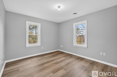 A room with wooden flooring and two framed pictures on the wall.