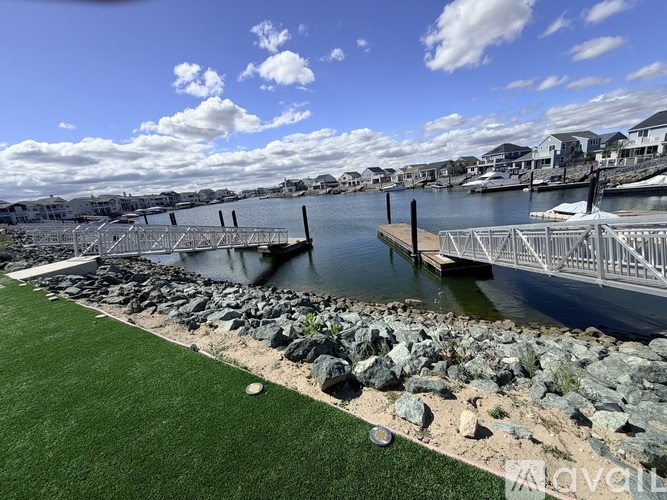 A patio with a couch and a view of boats in the water.