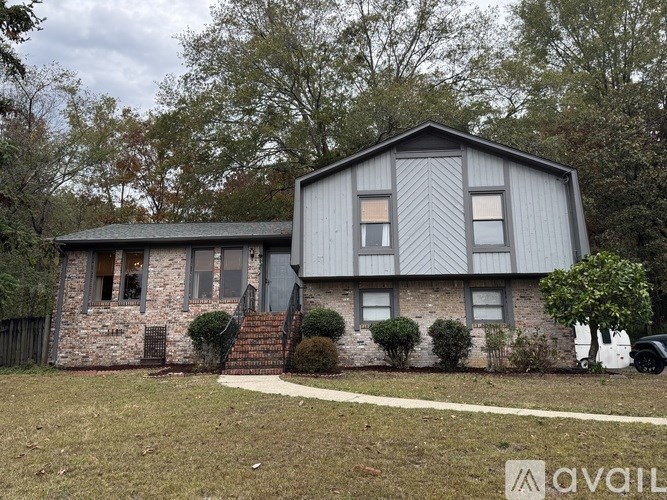A house with a grey roof and a white garage door is for sale.
