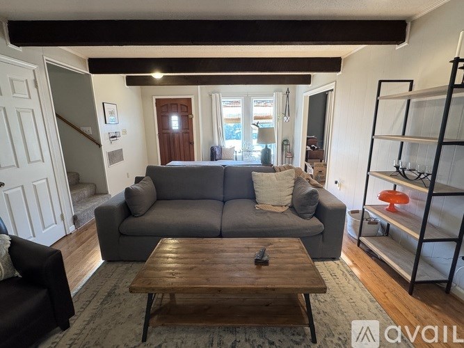 A living room with a grey couch and a wooden coffee table.
