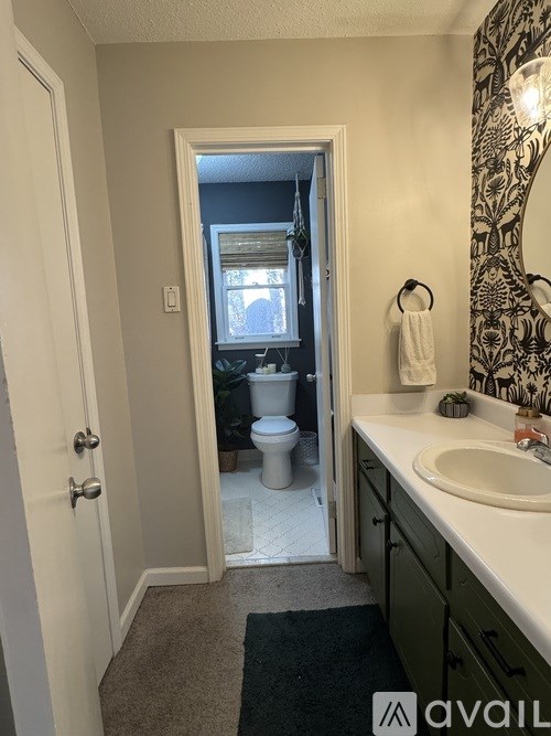 A bathroom with a toilet and sink visible through the door.