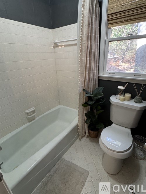 A white toilet sits next to a bathtub in a bathroom.