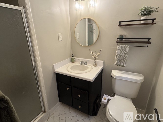 A bathroom with a toilet, sink, and mirror.