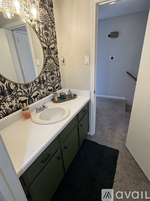 A bathroom with a sink, mirror, and a rug.